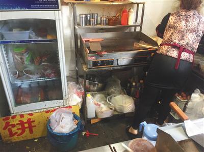 同时入驻了三家外卖平台的“台湾手抓饼”店内，老板娘正在加工食物，店内卫生条件差。后该店被查出无证经营。新京报记者 张越摄